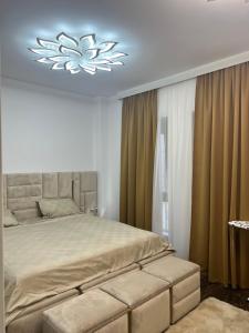una camera con un grande letto e un lampadario a braccio di Residence Future Delux IV a Giroc
