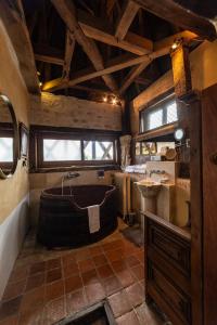 a large bathroom with a tub and a sink at Art'Hotel & SPA Le Potin Gourmand in Cluny
