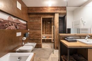 a bathroom with a white toilet and a sink at Apartments Chalet Anna in Ortisei