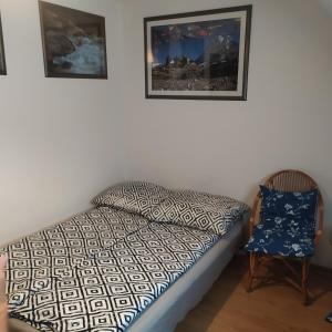 ein Bett und ein Stuhl in einem Zimmer in der Unterkunft Nad Dunajcem in Sromowce Niżne