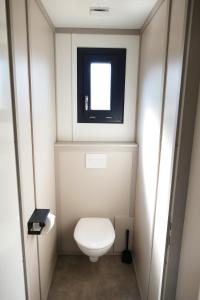 a small bathroom with a toilet and a window at Escales Voyages Cottage des Dunes - Chalet de 49m2 climatisé - 6 personnes in Jullouville-les-Pins +13 photos