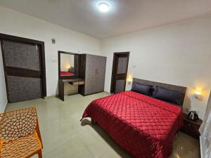 um quarto com uma cama vermelha e um espelho em July17 residency em Kodaikanal
