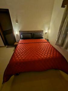 uma grande cama vermelha num pequeno quarto em July17 residency em Kodaikanal