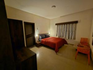 um quarto com uma cama vermelha e uma janela em July17 residency em Kodaikanal