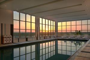a swimming pool in a building with a sunset in the background at Residence Inn by Marriott Calgary Airport in Calgary