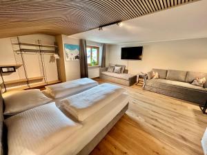 1 dormitorio grande con 2 camas y sofá en Haus Schrofenstein en Lech am Arlberg