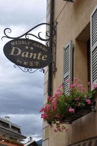 a sign on the side of a building with flowers at Meublé Albergo Dante in Bormio