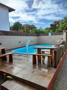 a patio with picnic tables and a pool at POUSADA MAR&ISA 2 in Itaúnas