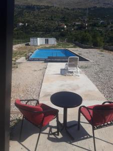 a table and two chairs and a swimming pool at Kamping Luke in Trebinje