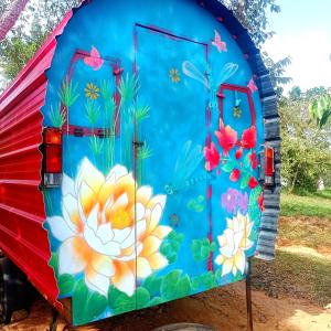 a blue door with flowers painted on it at La Pacha Hostel in Barichara