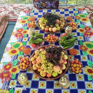 a table with plates of fruits and vegetables on it at Jumaboy Guesthouse 