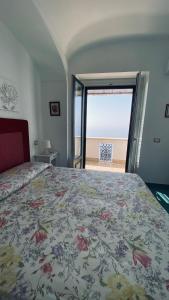 a bedroom with a bed with a view of the beach at Villa Sunrise. Pool and seaview in Amalfi Coast in Conca dei Marini