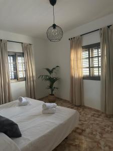 a bedroom with a large white bed with towels on it at Apartamento Fortaleza in Vallehermoso