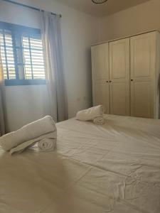 a bedroom with a large white bed with towels on it at Apartamento Fortaleza in Vallehermoso