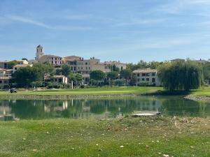 a pond in a park with buildings in the background at LES CISTES in Mallemort