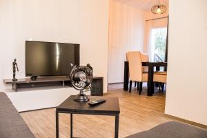 a living room with a television and a table at Apartments Olea in Biograd na Moru
