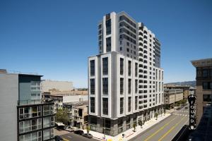 ein hohes weißes Gebäude mitten in einer Stadt in der Unterkunft AC Hotel by Marriott Oakland Downtown in Oakland