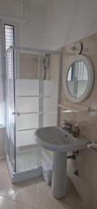 La salle de bains est pourvue d'un lavabo et d'un miroir. dans l'établissement LAMAR SUITES Seafront Apartments, à Misano Adriatico