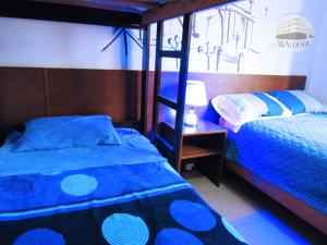 a bedroom with a blue bed and a bunk bed at Residencial Waldorf in Lima