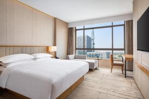 上海上海万信福朋喜来登酒店的一间带床和大窗户的酒店房间
