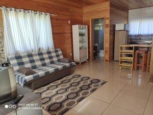 a living room with a couch and a kitchen at Cabanas das Araucárias in Urubici