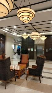 eine Lobby mit Stühlen, einem Tisch und Kronleuchtern in der Unterkunft ALEA RESIDENCES Condo near Airport and MOA! Cozy Place with Main street and Manila Bay view in Manila
