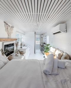 a white living room with a large white bed at Leobus-לאו באס in Menaẖemya