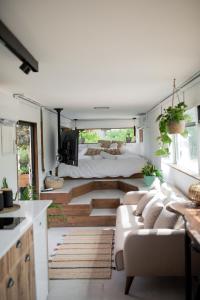 a living room with a bed and a couch in a room at Leobus-לאו באס in Menaẖemya