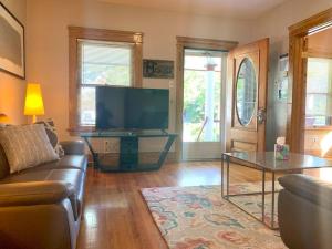 een woonkamer met een bank en een flatscreen-tv bij The House Hotels - Ridgewood Lower in Lakewood