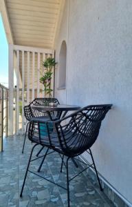 une chaise noire et une table sur une terrasse couverte dans l'établissement Muki House, à Hunedoara