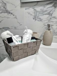 a basket of towels and toiletries on a bathroom counter at Muki House in Hunedoara +6 photos