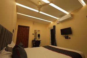 a bedroom with a bed and a ceiling fan at AMR Inn in Pondicherry