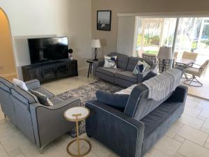 a living room with two couches and a television at Mermaids & Marlins Private House & Pool in Cape Coral