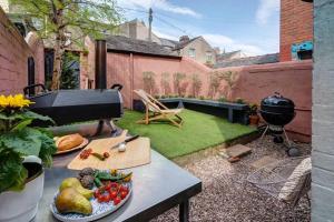 a backyard with a grill and vegetables on a table at Adelaide House in Ulverston