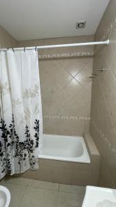 a white bath tub in a bathroom with a shower curtain at Mimi’s dream Luján in Luján +17 photos