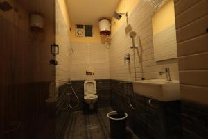 a bathroom with a white toilet and a sink at AMR Inn in Pondicherry