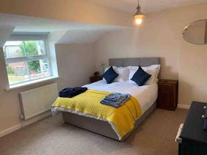 a bedroom with a bed with a yellow and blue blanket at Newton Hall farm cottage with amazing views & hot tub in Preston