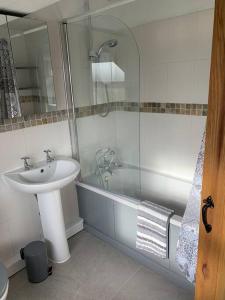 a bathroom with a sink and a shower and a tub at Newton Hall farm cottage with amazing views & hot tub in Preston