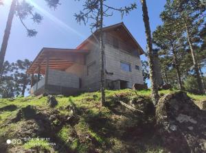 a house on top of a hill with trees at Cabanas das Araucárias in Urubici