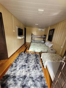 a room with two beds and a tv in it at Pousada Justi Oliveira in Lauro Müller