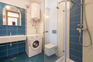 a bathroom with a washing machine next to a shower at Villa Novak in Okrug Donji +71 photos