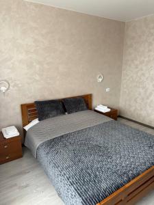 um quarto com uma cama grande e duas mesas de cabeceira em PerfectHotel em Myrhorod