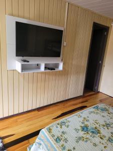a living room with a television on a wall at Pousada Justi Oliveira in Lauro Müller