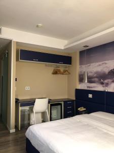 ein Schlafzimmer mit einem weißen Bett und einem weißen Stuhl in der Unterkunft Hotel La Rocca in Nogarole Rocca