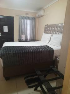 een slaapkamer met een groot bed en een raam bij Beautiful Gate Guesthouse in Palatswe