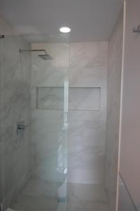 een douche met een glazen deur in de badkamer bij Silva Domus in West Orange