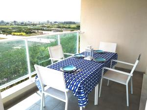 a table with chairs and a blue and white table cloth at PRECIOSO APARTAMENTO PLAYA DE PILES in Piles