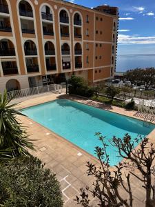 a large swimming pool in front of a building at FRONTIÈRE MONACO in Beausoleil