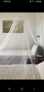 a white bed with a canopy in a bedroom at House Anastasia in Agios Georgios Pagon