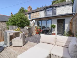 a living room with a white couch on a patio at Aster Cottage in Rhyl